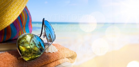 Straw hat, bag and sun glasses  on a tropical beach